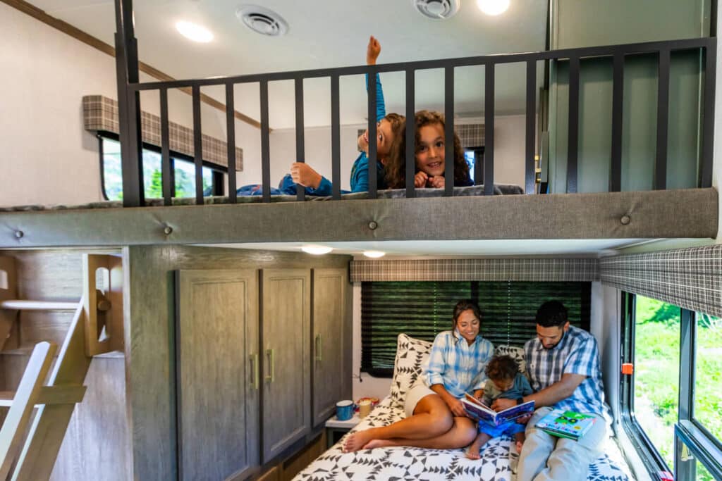 Kids in upper loft bunk of Eddie Bauer fifth wheel