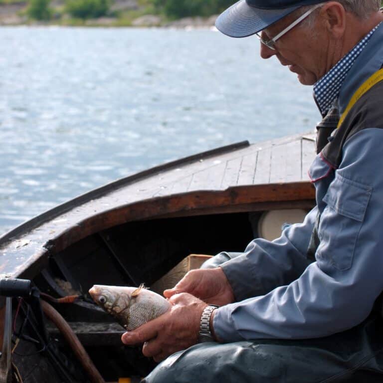 fisherman with a fish in hands