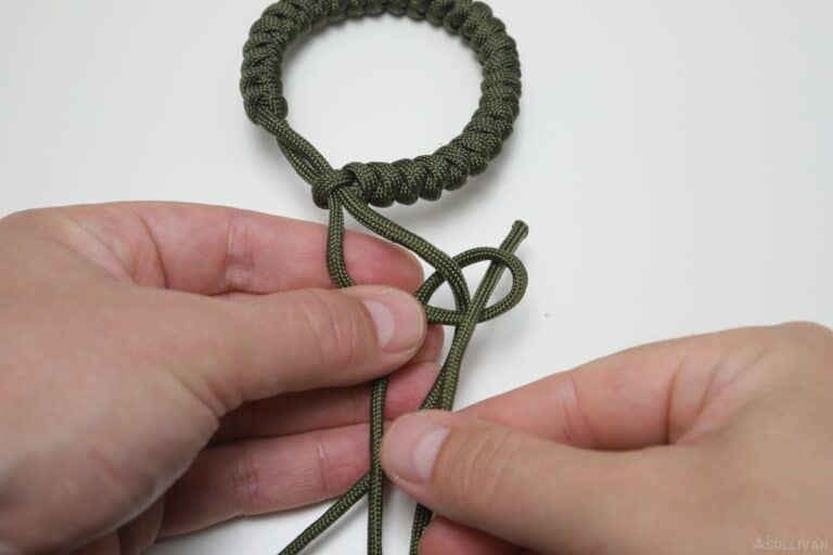 snake knot paracord bracelet passing free end through the final loop