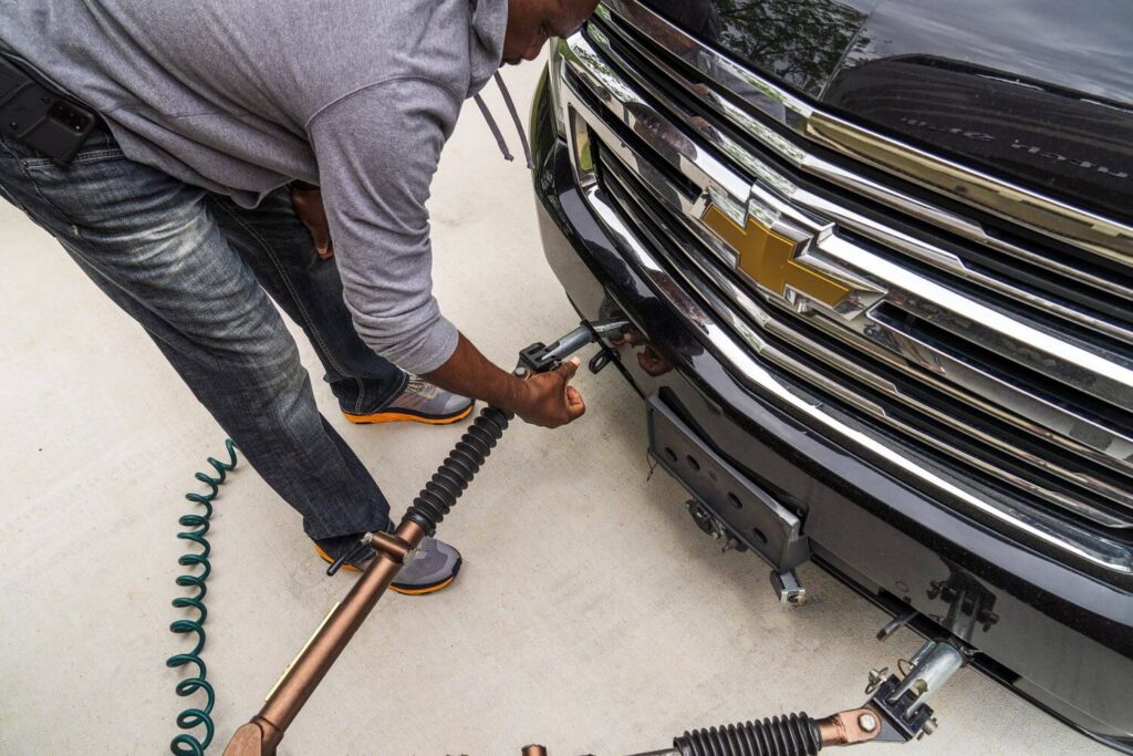 Man attaching tow bars to dinghy vehicle