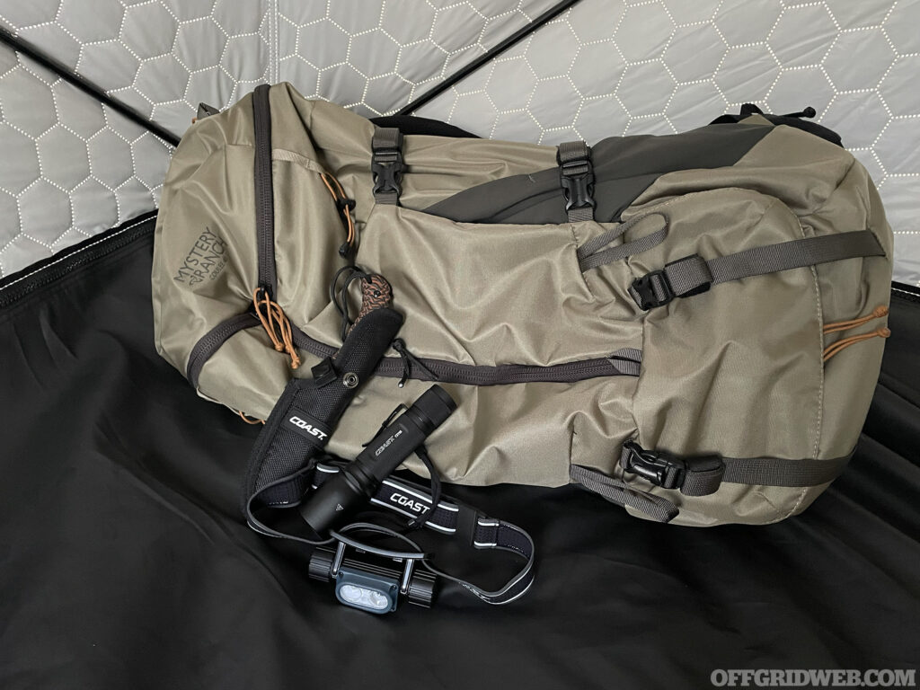 Mystery Ranch backpack with a Coast knife and headlamp.