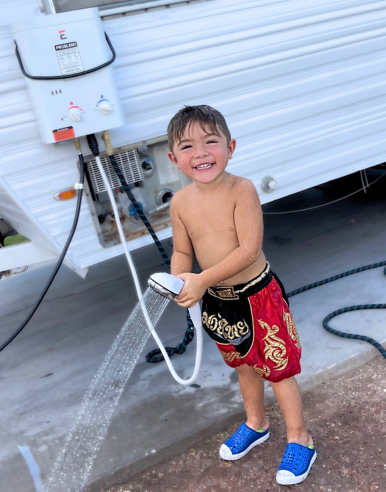 Boy smiling using Eccotemp tankless water heater