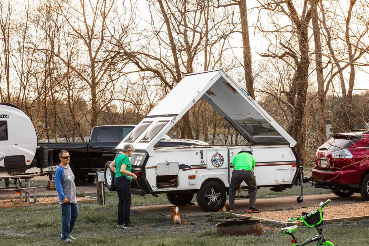 People gathered around a pop-up A-frame camper