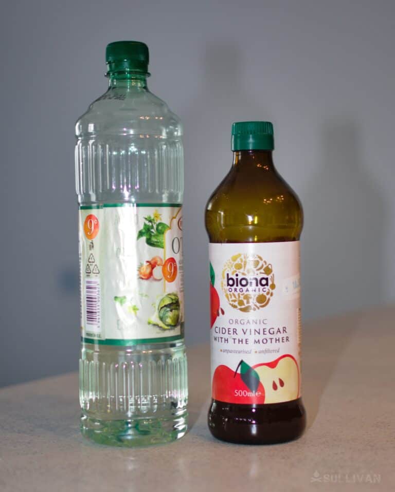 bottle of vinegar next to bottle of apple cider vinegar on kitchen counter