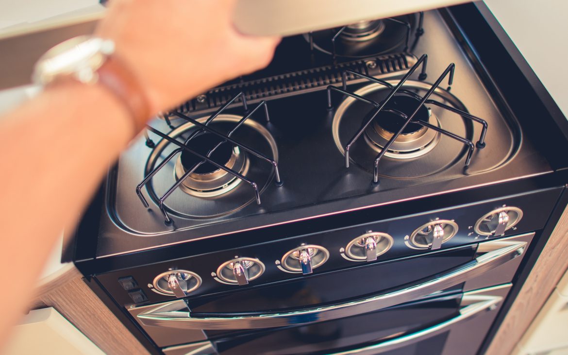 Checking on Camper RV Propane Stove. Cooking While Travel Theme.