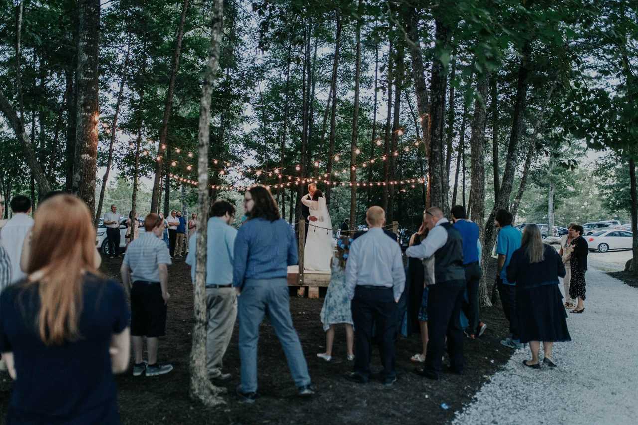 An outdoor wedding with attendees watching bride and groom.