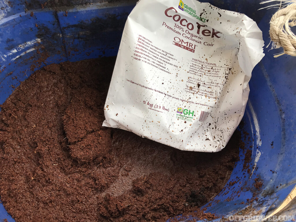 A bag of coconut coir being dumped into a bucket.