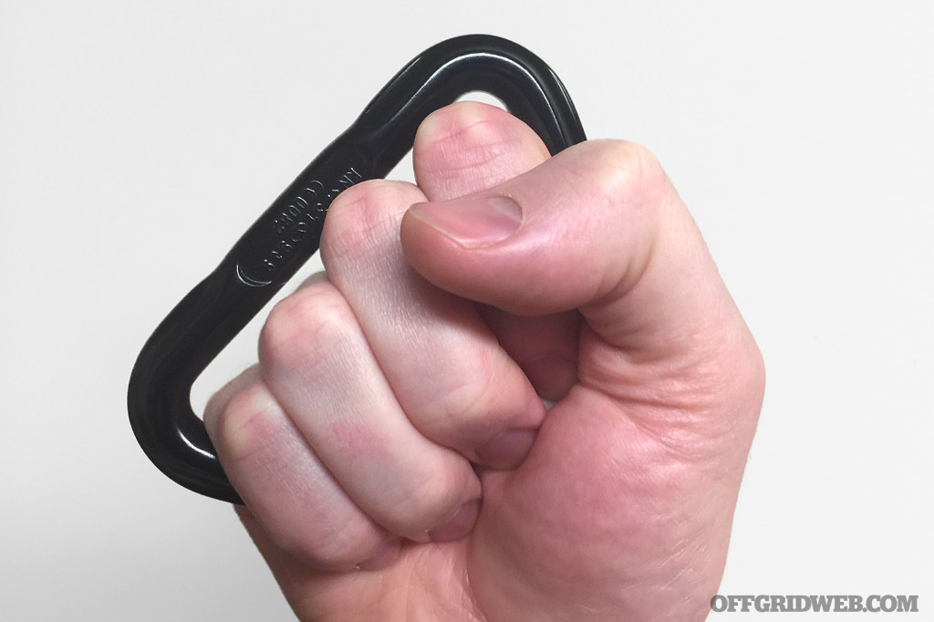 Photo of a fist holding a D-ring as a carabiner knuckles self defense tool.