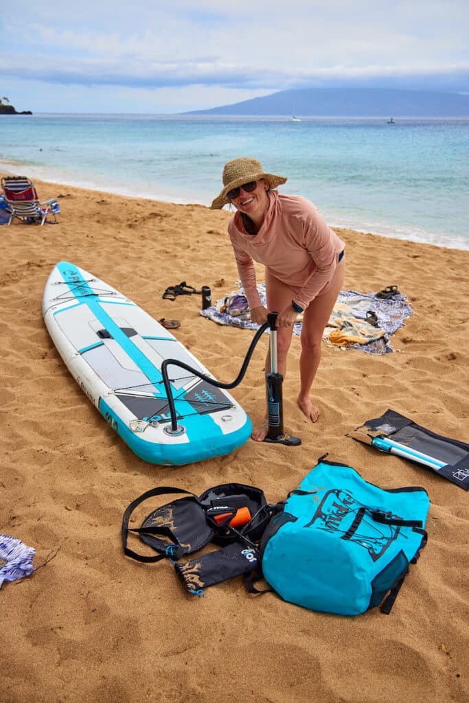 Kristen Bor blowing up paddleboard on Maui at Kahekili Beach Park