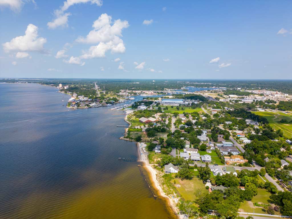 An aerial view of Sanders Beach in Pensacola, Florida, Pensacola Bay is visible to the left of the photo while the city is on the right.