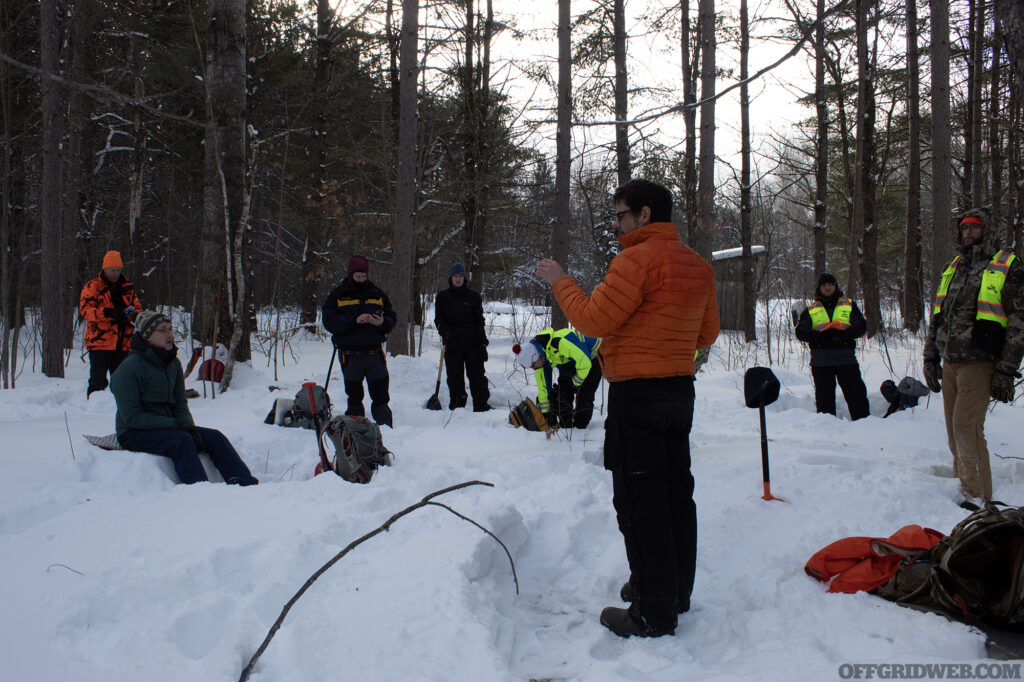 Students during winter survival training discuss several fire starting techniques.