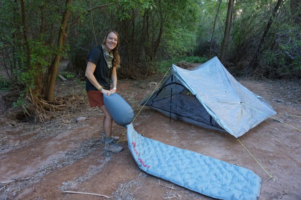 Woman blowing up the Ether sea to summit sleeping pad