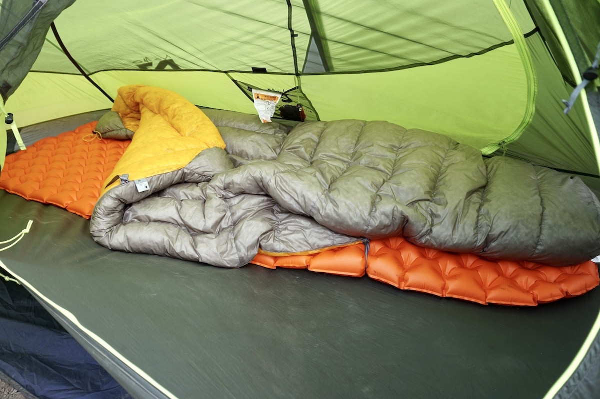 Sleeping bag on top of sleeping pad in backpacking tent