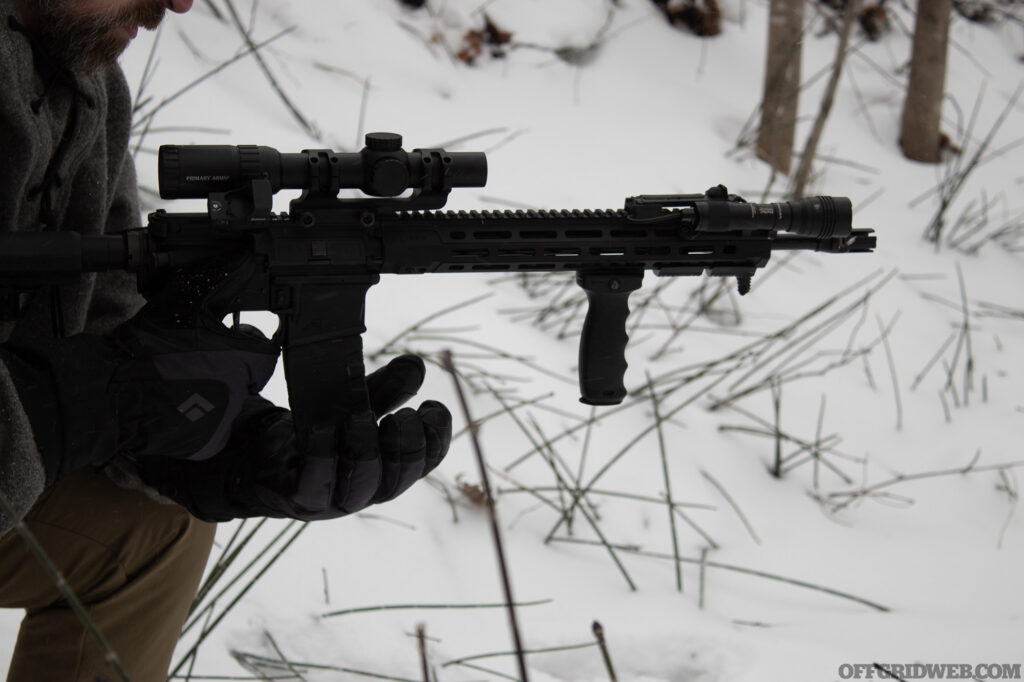 Photo of a man inserting a magazine into a winter ready AR lower.