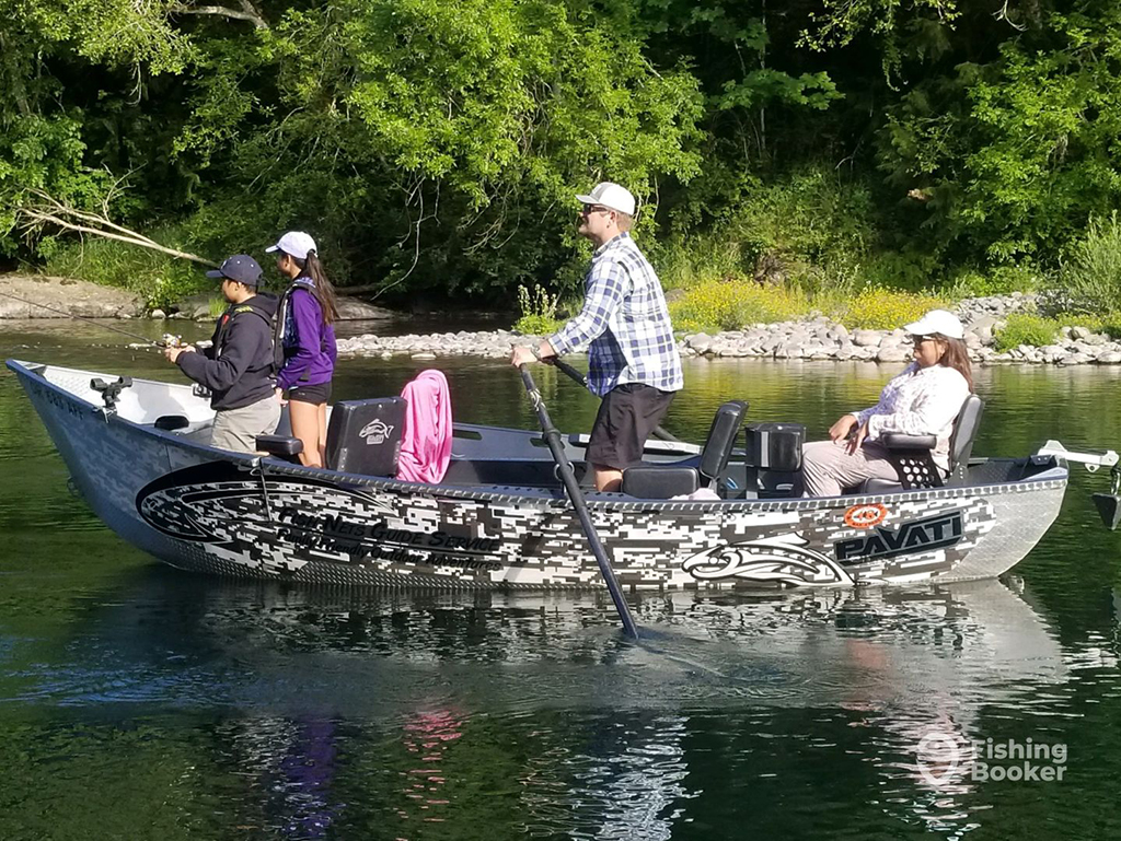 A family of anglers standing to attention as they embark on a fishing charter with a guide in Eugene, Oregon aboard a rowing boat on a river