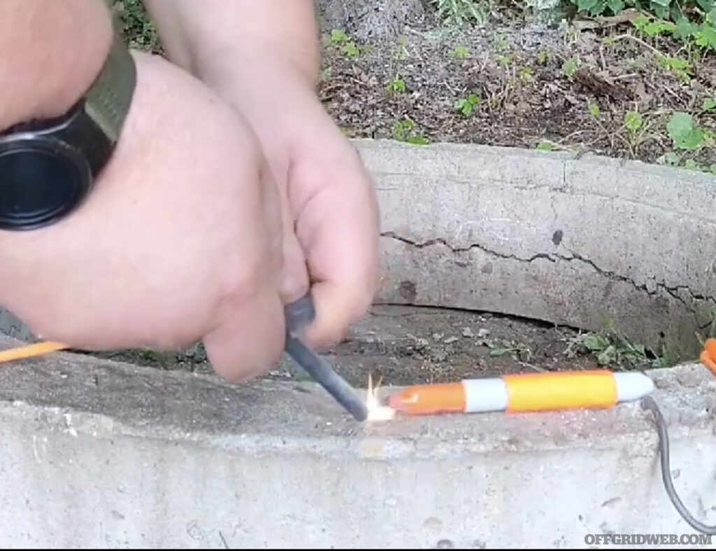 Photo of a sharpie marker being lit on fire with a ferro rod.