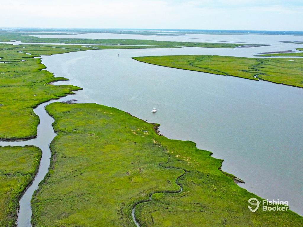 An aerial view of rivers and back bays with a singular small fishing boat near shore near Wildwood, NJ