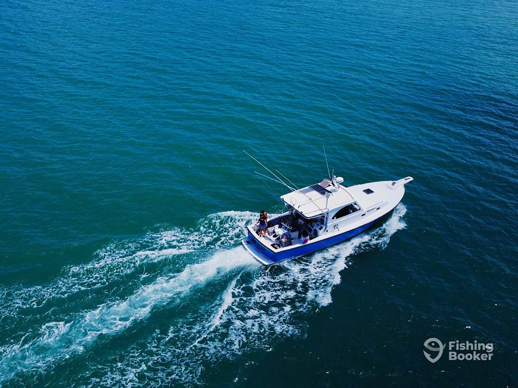An aerial view of a fishing charter speeding off into the deep waters of the Caribbean from San Juan, Puerto Rico on a clear day