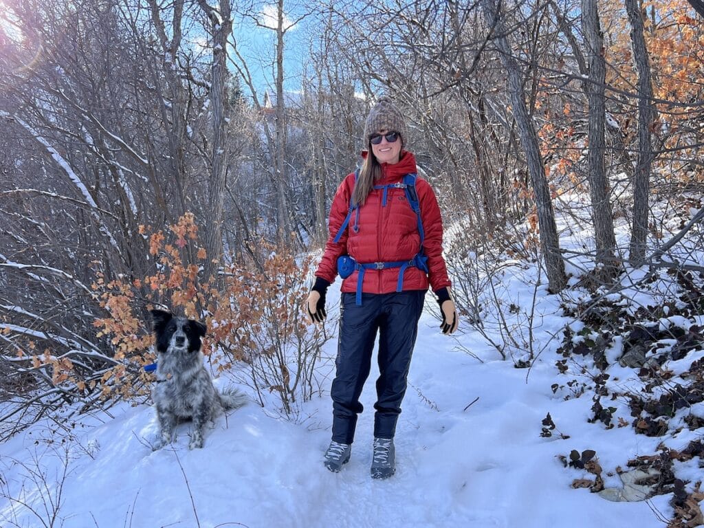 Bearfoot Theory founder Kristen Bor on a winter hike with her dog wearing REI Co-op Flash Insulated Hybrid Pants