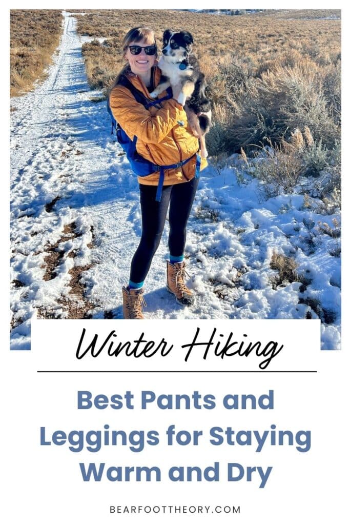 A pinnable image of a woman holding a mini aussie on a snowy trail with the text "winter hiking - best pants and leggings for staying warm and dry"