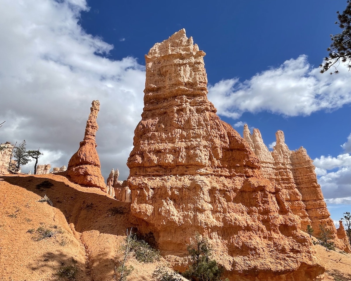 Queen Victoria hoodoo in the Queens Garden section of the Queens Garden Trail in Bryce Canyon National Park. There is a blue sky and clouds in the background.