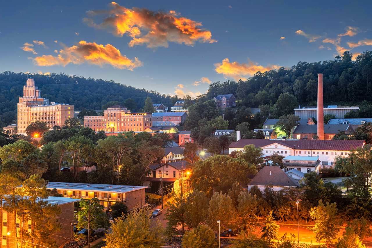 Scenic town built on hillside against a sunset sky.