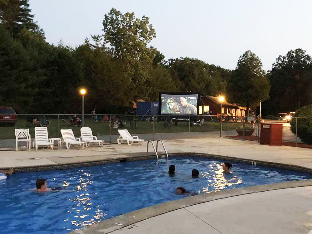 People in a pool watching TV.