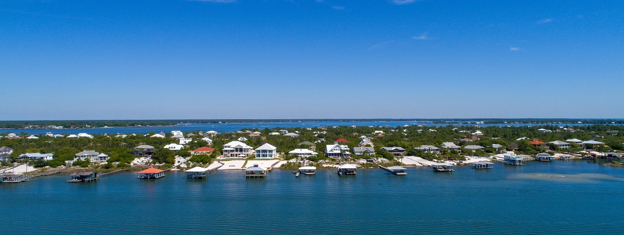 Aerial view of boats docked along a lush coastlin.