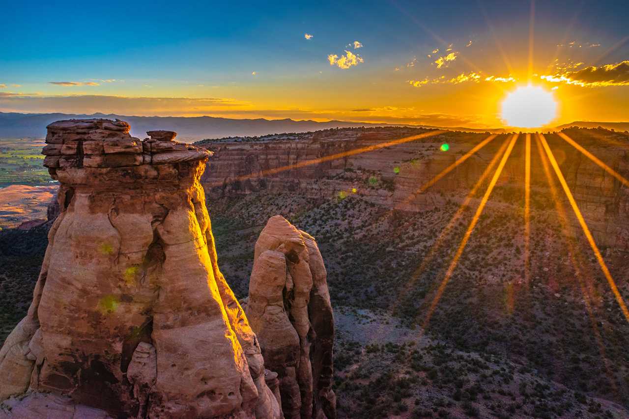 Sun dips over rocky desert landscape.