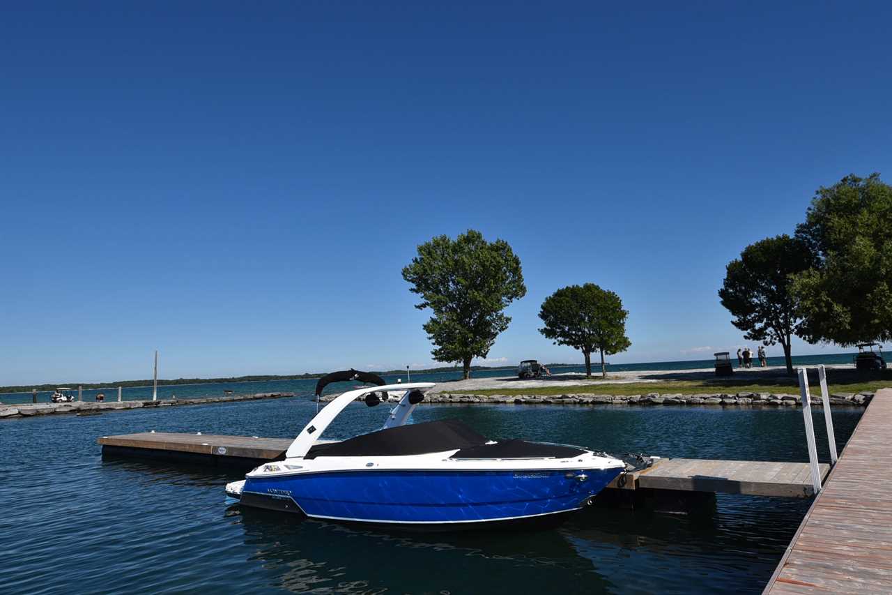 A blue boat moored on a wooden dock near jetty.