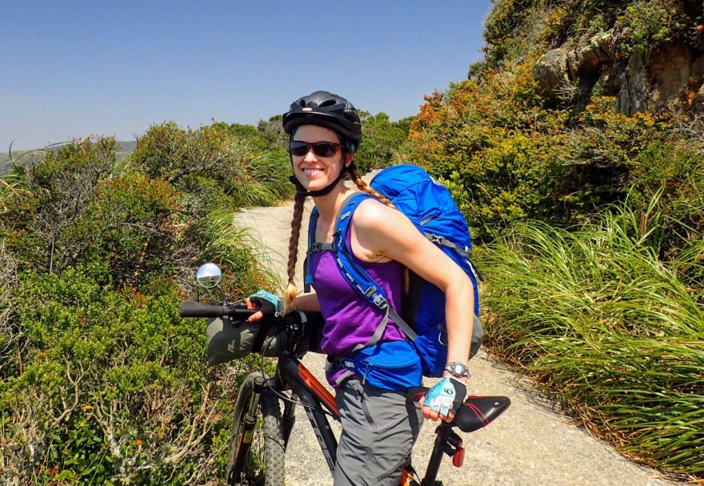 Woman earing a backpack on a bikepacking trip