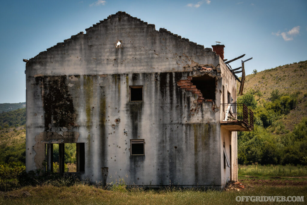 A ruined building in the middle of a field.