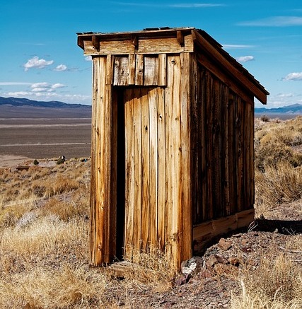 OUTHOUSE IN A FIELD