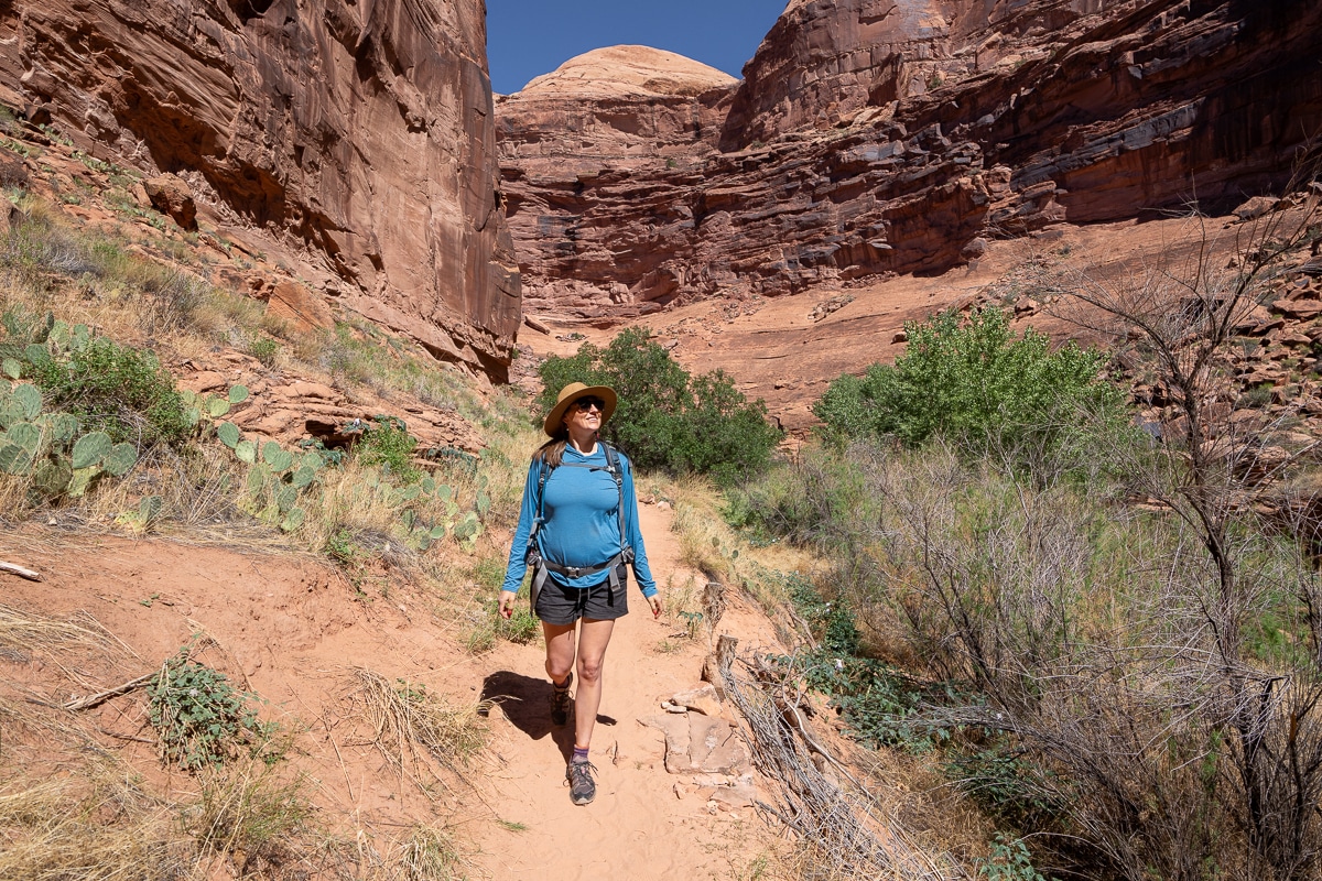 Bearfoot Theory founder Kristen Bor hiking on a sandy trail in a Moab Utah canyon while pregnant