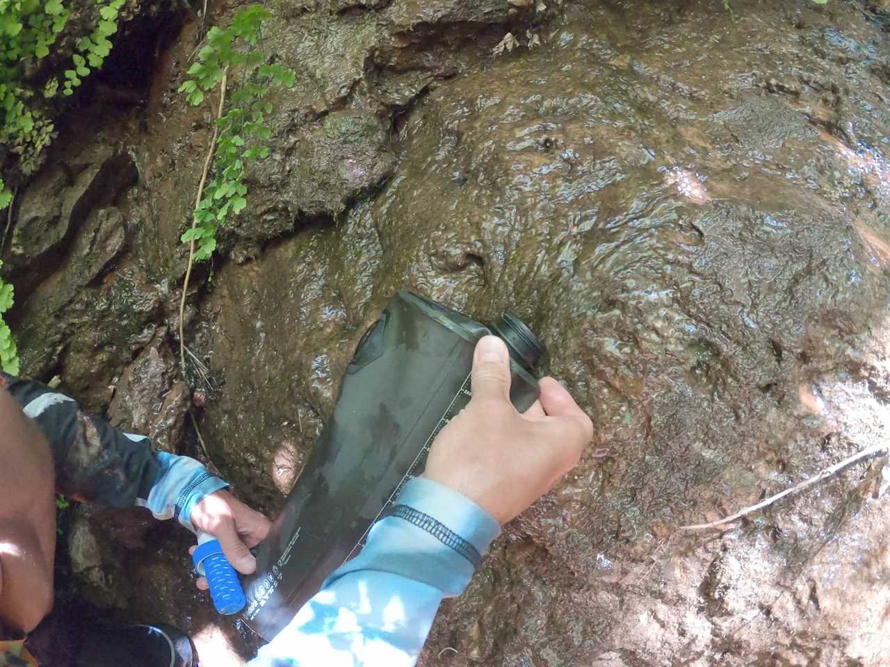 Filling up water bottle from a desert spring