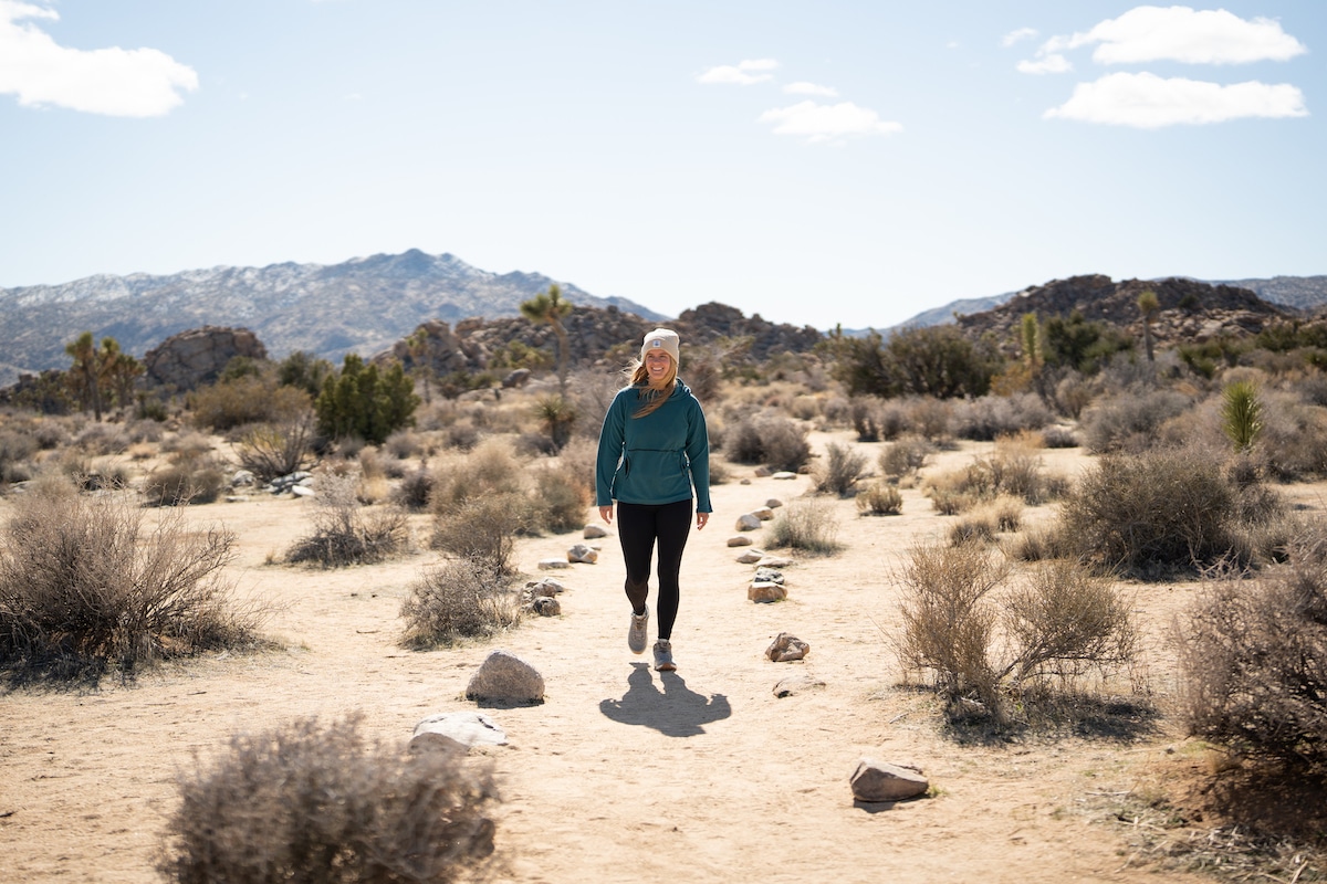 A female hiker wearing the Oboz Cottonwood mid waterproof hiking boots in the color Drizzle on a trail in Joshua Tree National Park