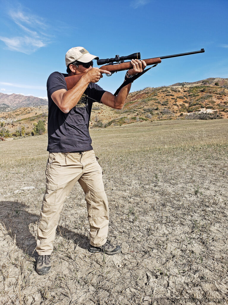 Photo of a man standing with a firearm.