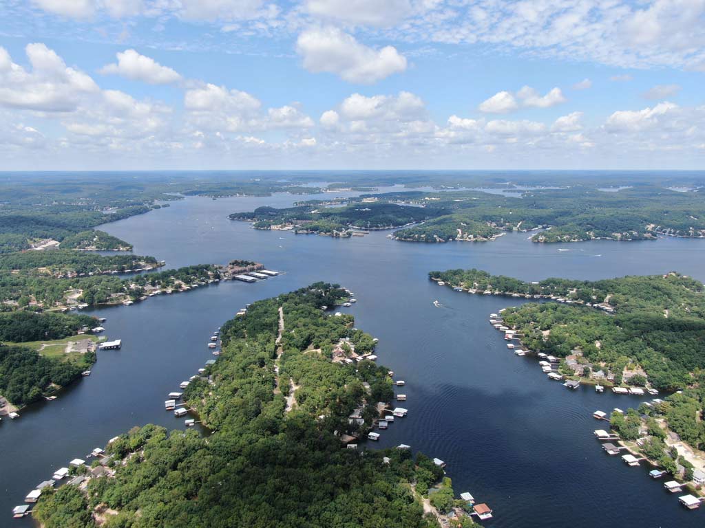 An aerial shot of Lake of the Ozarks in Missouri, showcasing the unique shape of the lake, as well as numerous lake houses peppered along the shores.