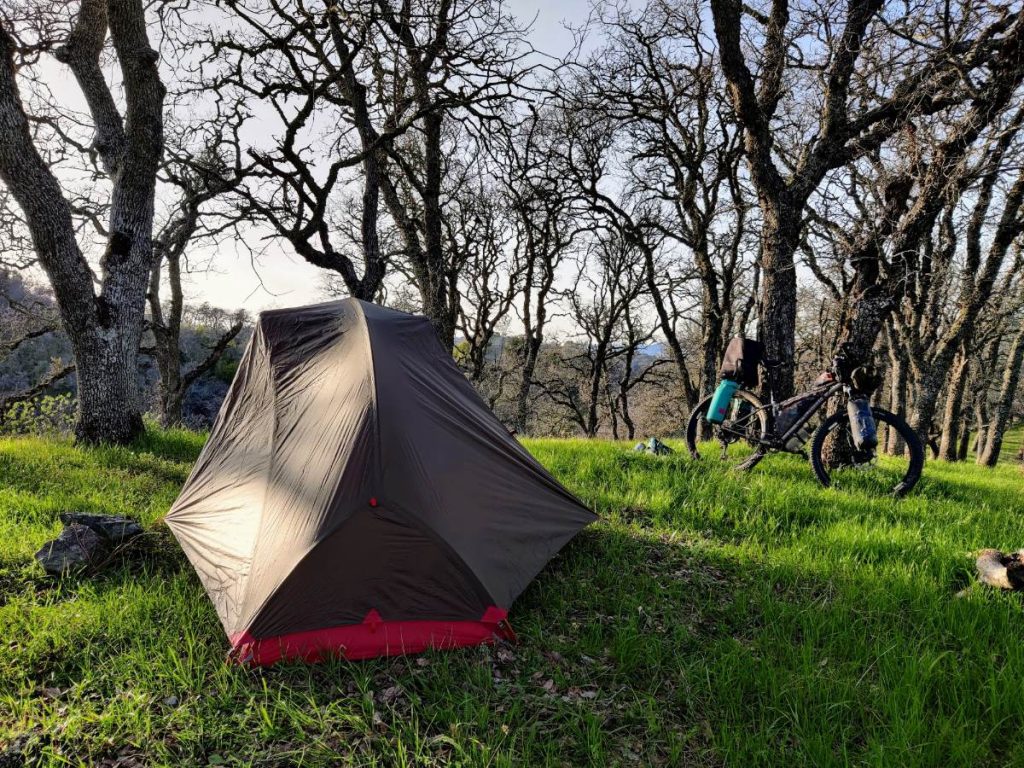 Hubba Hubba Bikepack 1-person tent in grassy campsite with bikepacking bike in background