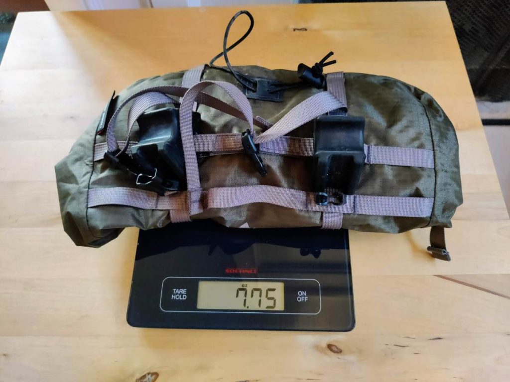 The Hubba Hubba's bikepacking handlebar bag on a scale reading 7.75 oz