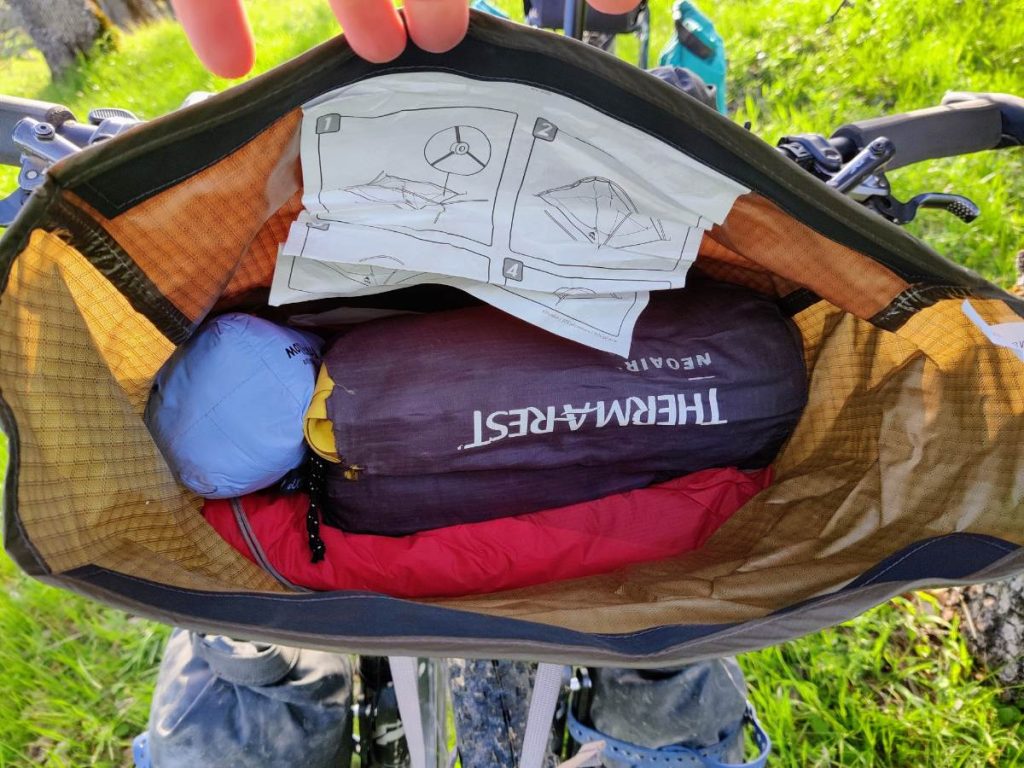 Looking down into the handlebar bag with sleeping pad and tent inside