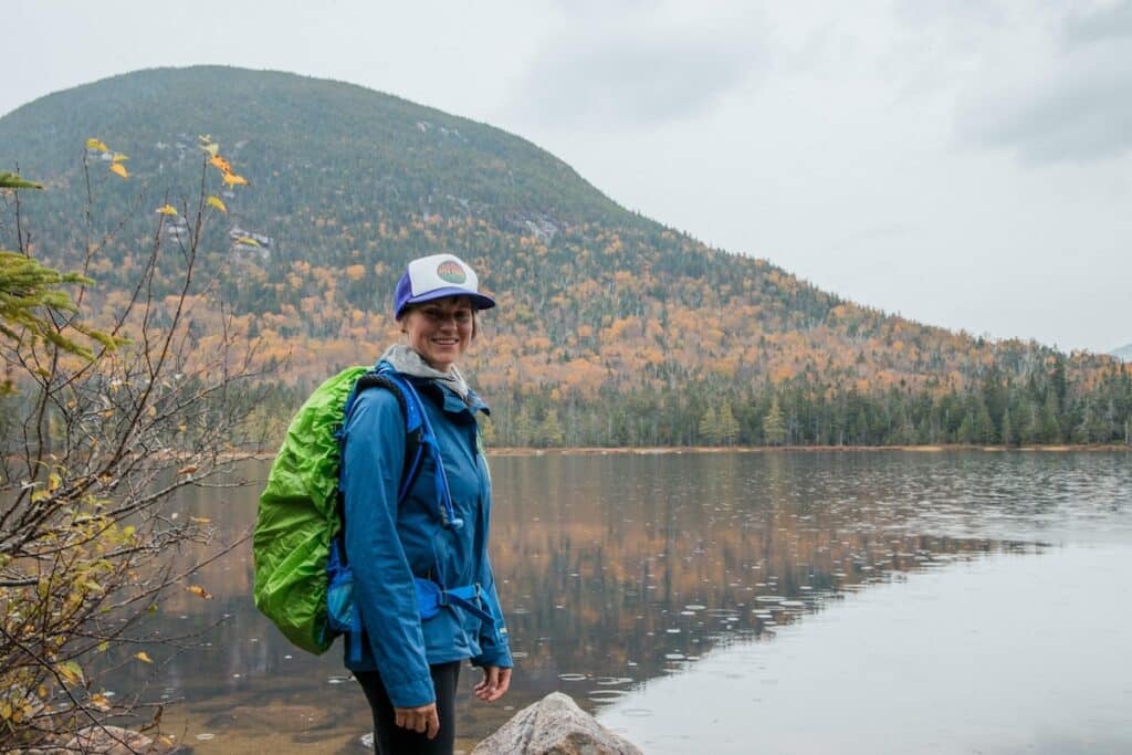 Woman smiling for photo in front of a lake in New Hampshire in the fall