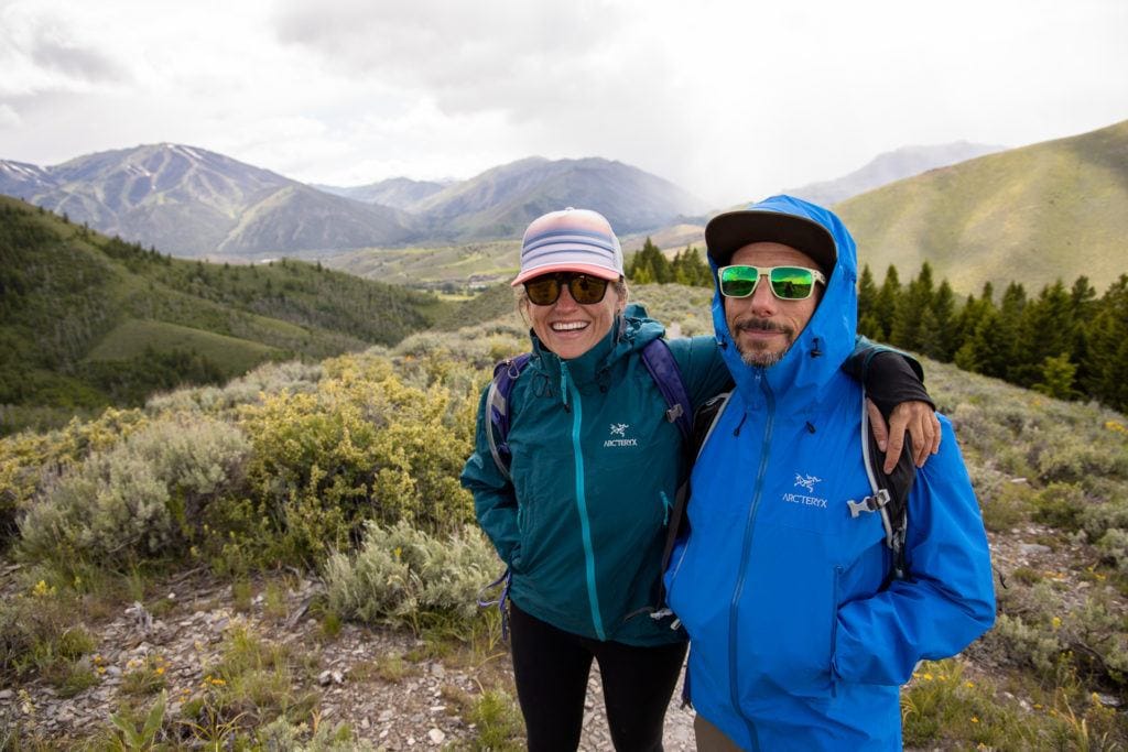 A woman and man hiking in the rain in Sun Valley Idaho. Both are wearing waterproof rain jackets.