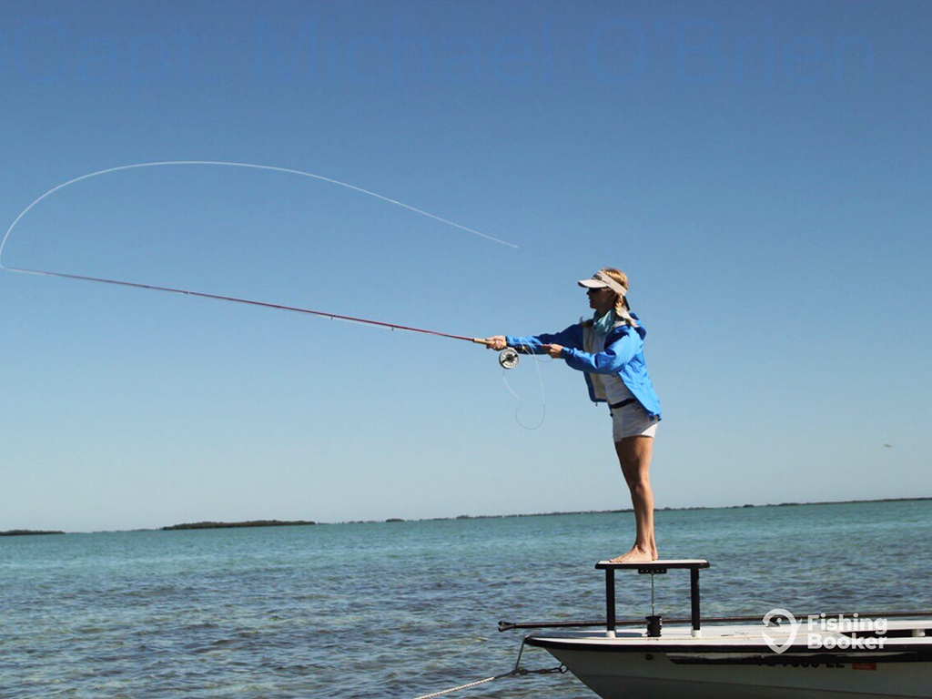 A female angler casts into the shallow flats of Key West while fly fishing in the evening