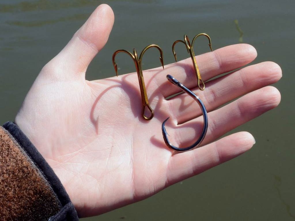 A photo showing a hand holding three different types of the hooks