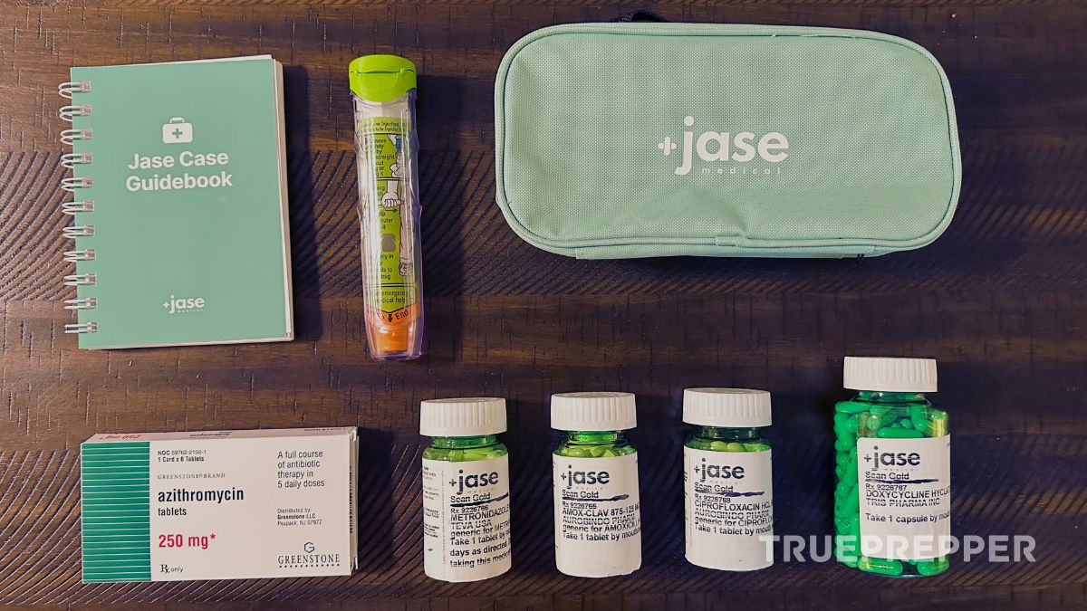 Jase Case antibiotics contents organized on wooden table with guidebook and add-on EpiPen.