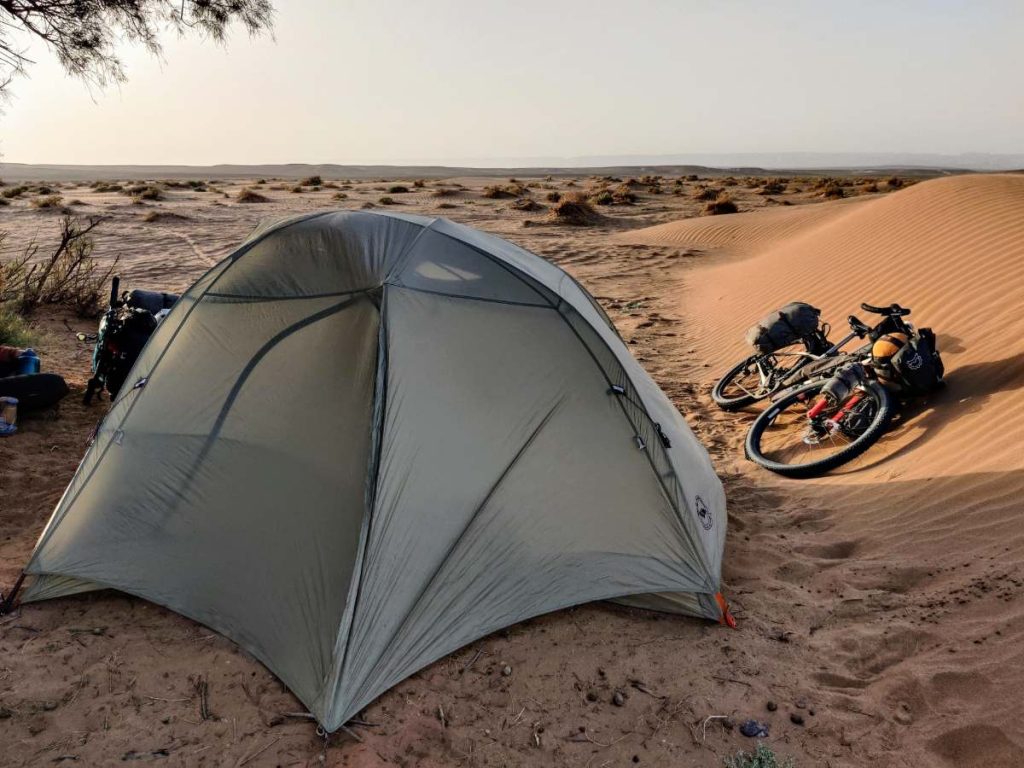 Bikepacking tent strains in the wind at a desert campsite