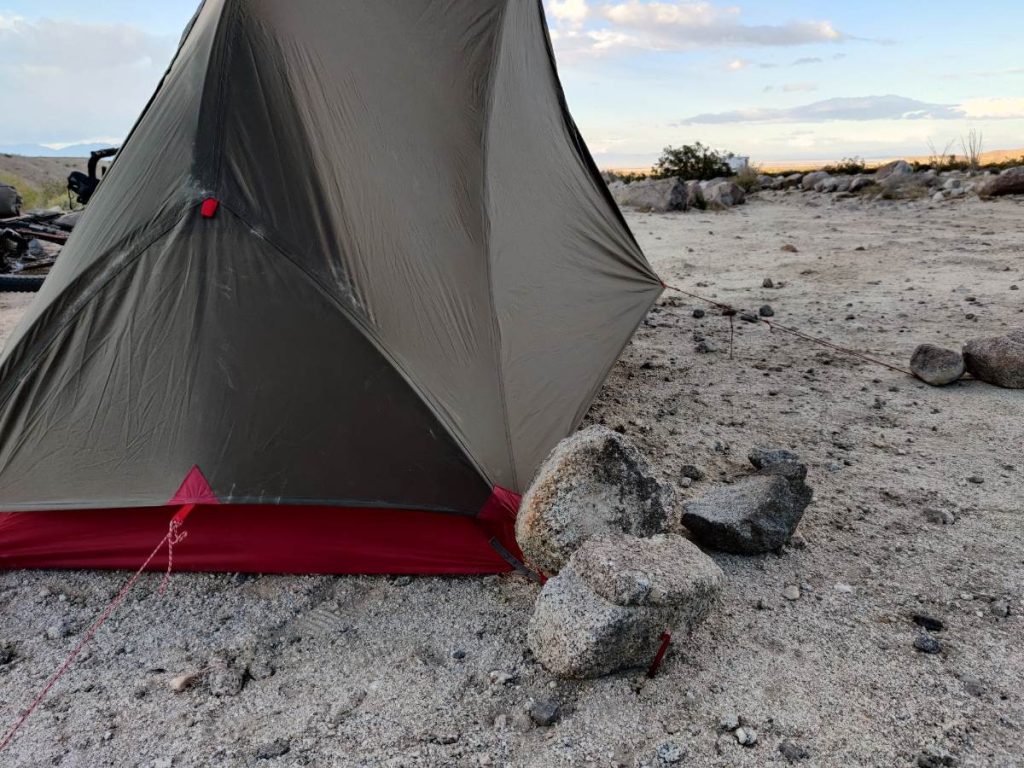 Hubba Hubba bikepack tent with rocks on top of stakes for extra strength in the wind