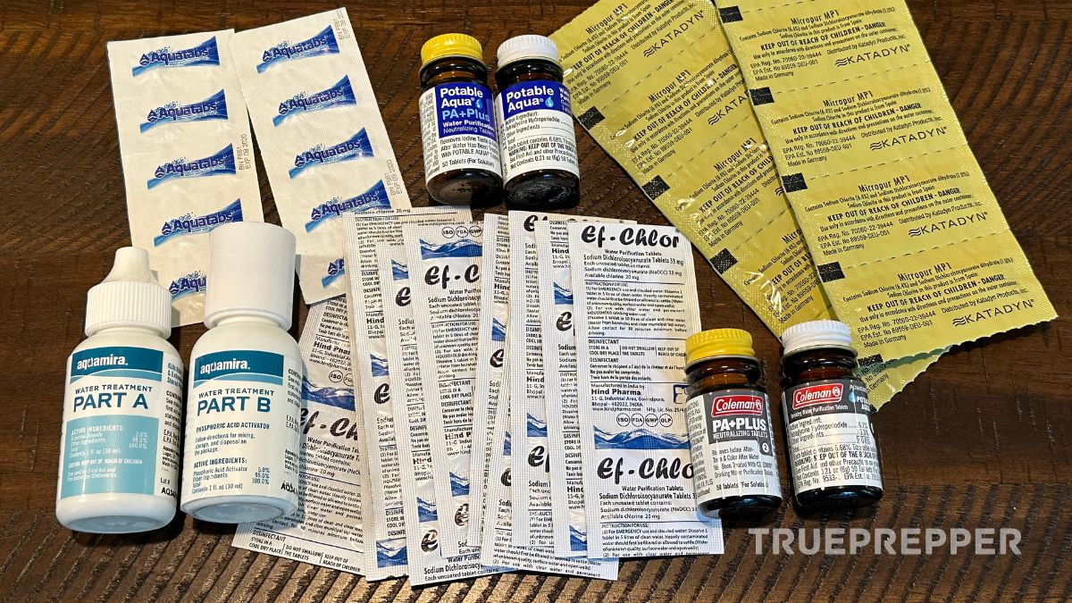 Many types of water purification tablets laid out on a table for review.