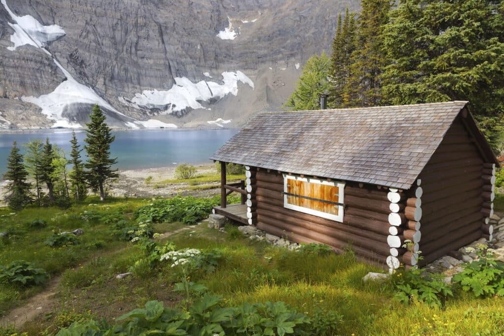 Cabin sitting next to alpine lake in backcountry of British Columbia